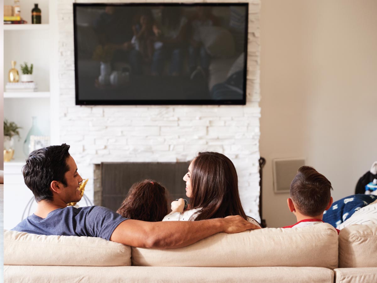 Family sitting on couch in their new home.